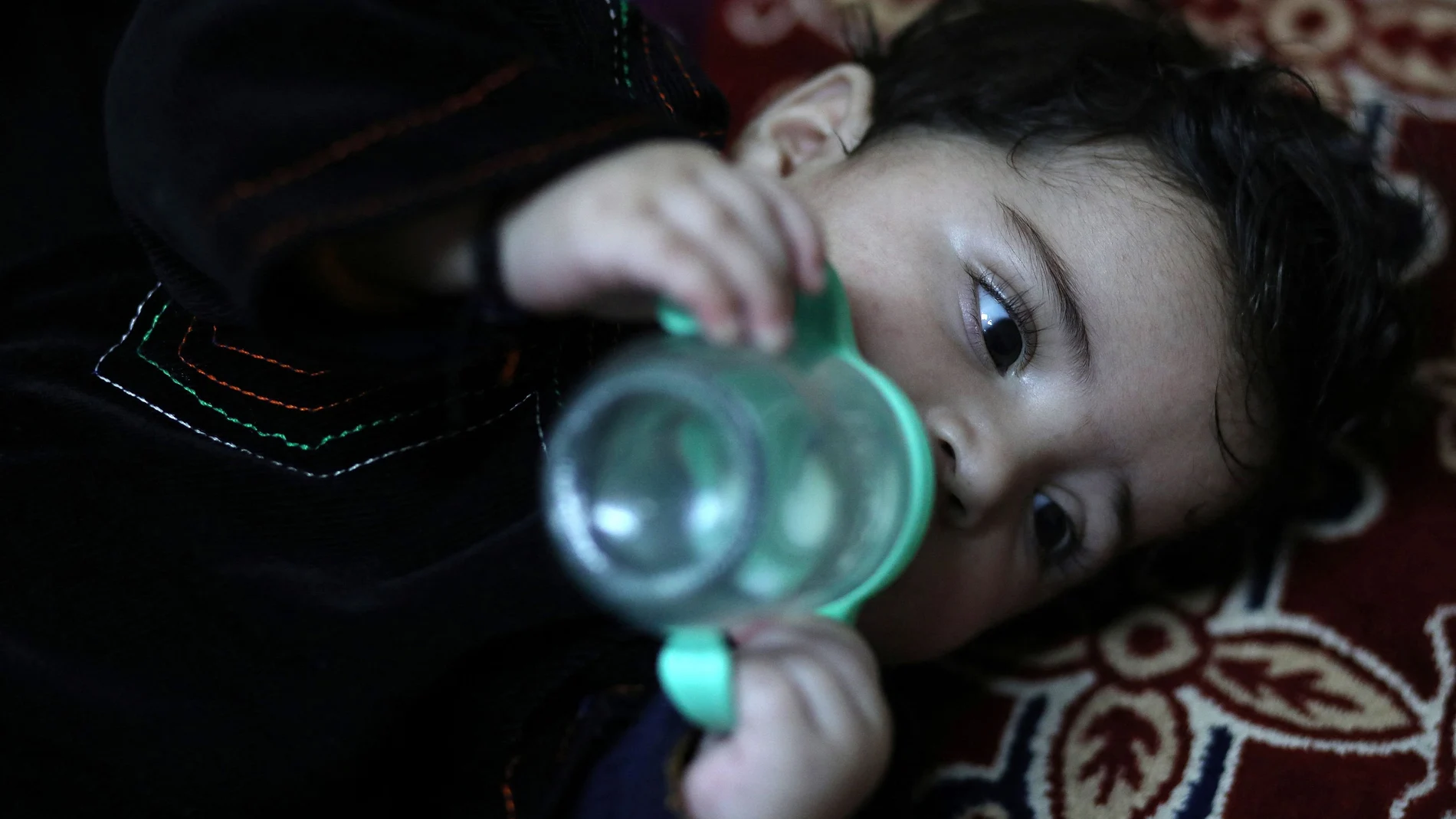 El bebé Sohail Ahmadi bebe leche de su biberón en la casa de Hamid Safi, el taxista que le recogió del aeropuerto internacional de Kabul