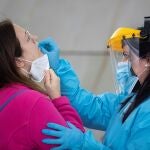 Una sanitaria realiza un test de antígenos a una mujer