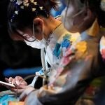 Yokohama (Japan), 10/01/2022.- A kimono-clad young Japanese woman looks at her smartphone as she attends a Coming of Age Day ceremony at Yokohama Arena amid the coronavirus disease (COVID-19) pandemic, in Yokohama, south of Tokyo, Japan, 10 January 2022. Coming of Age Day celebrates all those who reached 20 years of age, which is considered adulthood in Japan. (Japón, Tokio) EFE/EPA/FRANCK ROBICHON