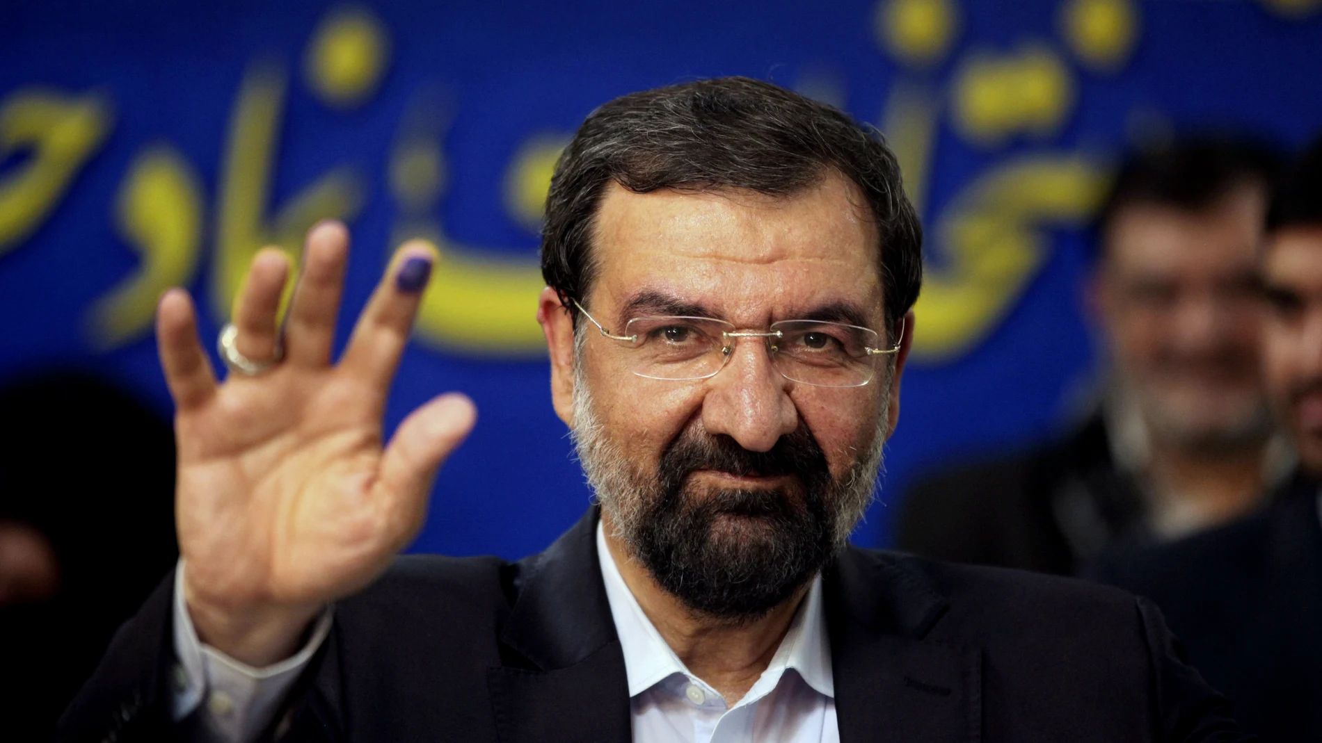 FILE - Mohsen Rezaei waves to reporters after registering as a presidential candidate, in Tehran, Iran, May 10, 2013. Argentinaâ€™s Foreign Ministry said Tuesday, Jan. 11, 2022, that the appearance of Rezaei, at the investiture of Nicaraguaâ€™s president on Monday was â€œan affront to Argentine justice and to the victims of the brutal terrorist attackâ€³. Rezaei, a former leader of Iranâ€™s paramilitary Revolutionary Guard, is wanted by Argentina on an Interpol â€œRed Noticeâ€ alleging he was involved in the 1994 bombing of a Jewish center in Buenos Aires that killed 85 people. (AP Photo/Vahid Salemi, File)