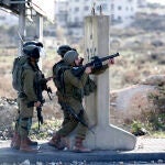 Soldados israelíes apuntan con sus armas a palestinos en Cisjordania en una foto de archivo