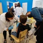 Un padre acompaña a su hijo mientras la vacunan en el CEIP Blasco de Alagón de Vilafranca (Castellón) durante el inicio de la segunda fase de la campaña de vacunación pediátrica, a 13 de enero de 2022