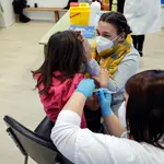 Una madre acompaña a su hija mientras la vacunan en el CEIP Blasco de Alagón de Vilafranca durante el inicio de la segunda fase de la campaña de vacunación pediátrica contra el coronavirus que comenzó el jueves