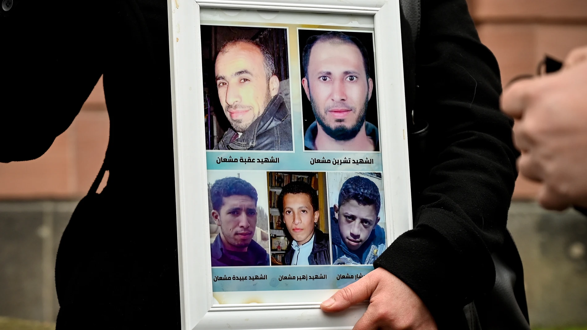 Yasmen Almashan muestra fotos de sus hermanos muertos en Siria antes del veredicto contra el coronel Anwar Raslan
