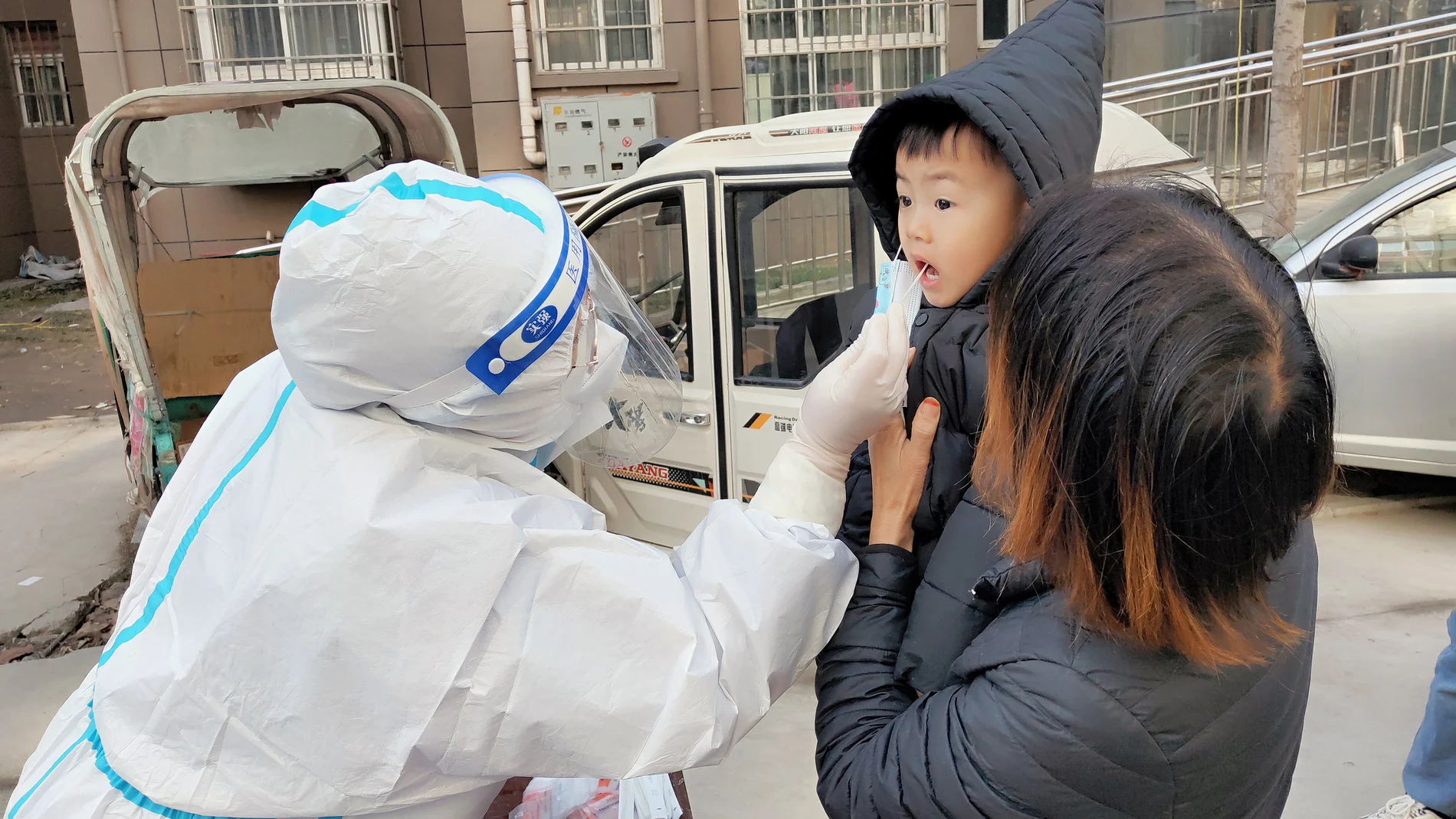 Un sanitario realiza un test a un niño en Huaxian, China
