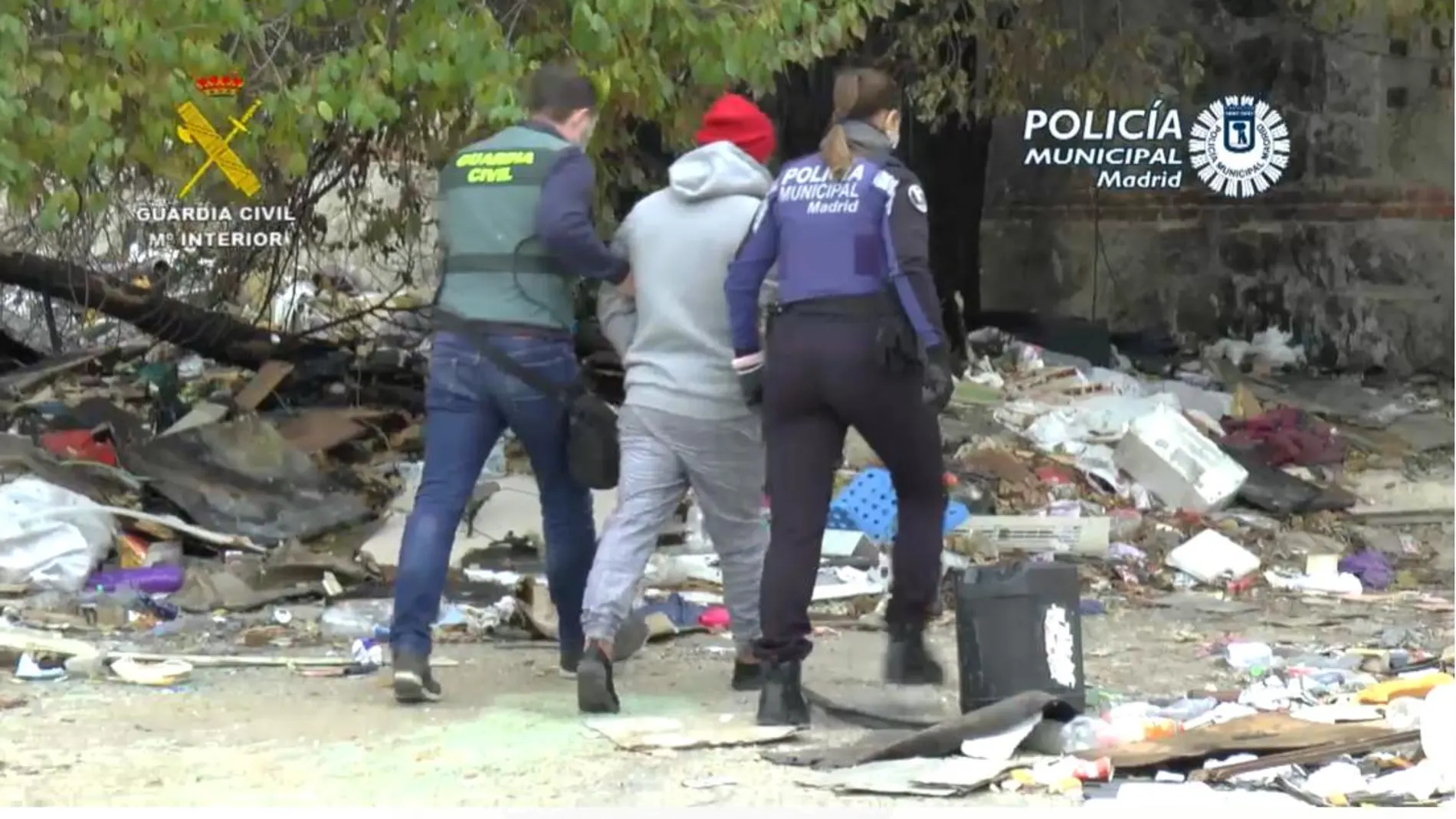 Agentes de la Guardia Civil conducen a uno de los detenidos