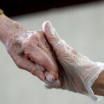 Una mujer da la mano a su madre en la residencia Orpea Aravaca, de Madrid