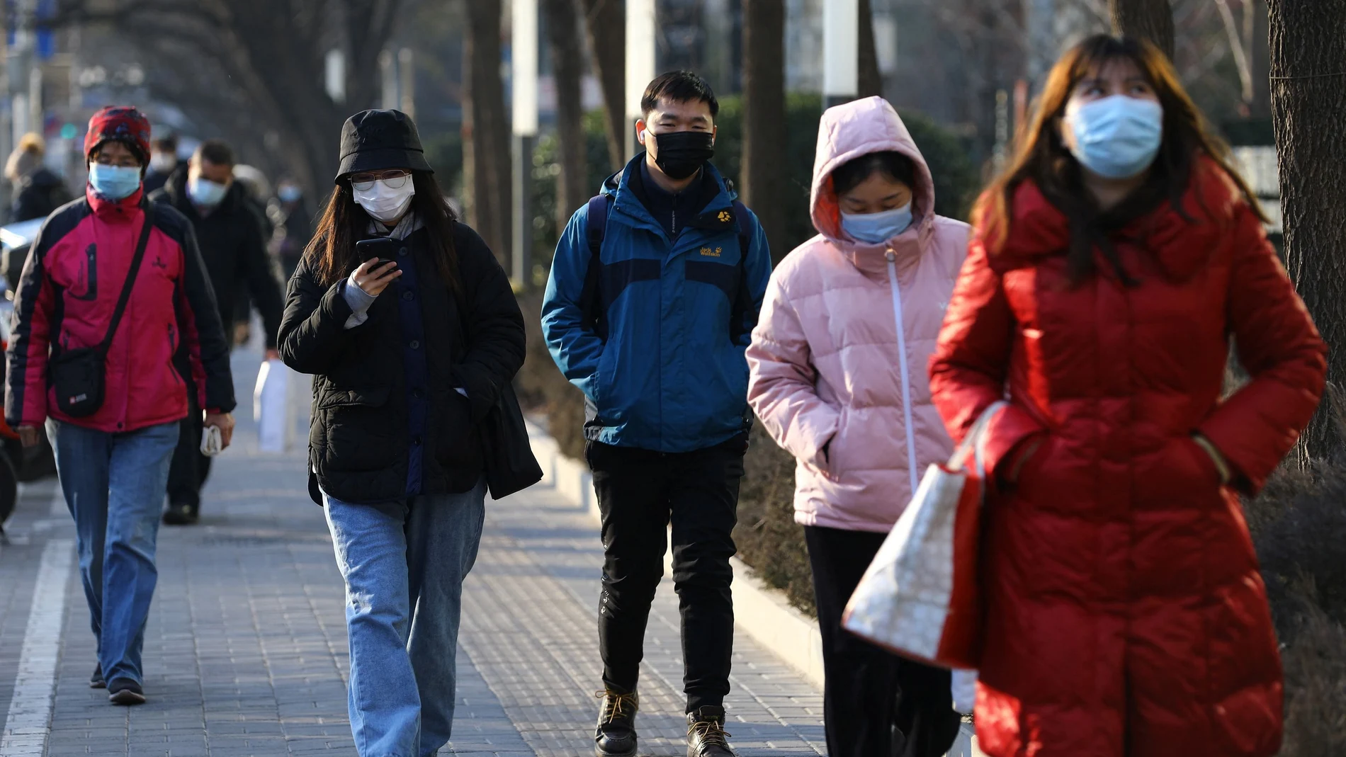 Varias personas con mascarilla en Beijing