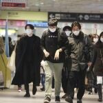 Personas con mascarillas caminan por una estación de tren en Tokio