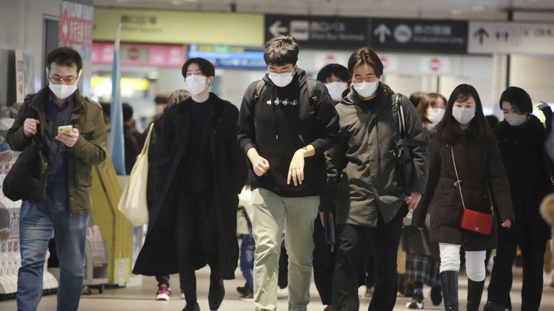 Personas con mascarillas caminan por una estación de tren en Tokio