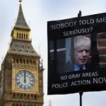 Una pancarta reclama que la Policía investigue a Boris Johnson por el «Partygate» durante una protesta frente al Parlamento