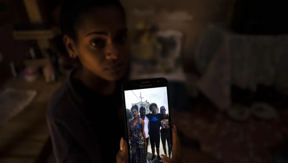 María Carla Milan Ramos muestra una foto en su teléfono móvil de su marido con sus hermanos, que están todos en prisión acusados de participar en las recientes protestas contra el gobierno, en su casa en el barrio de La Guinera de La Habana