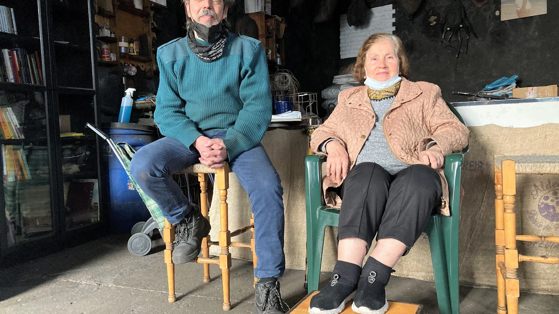Luis Aguilar Astola, de 56 años, junto a su madre Carmen Astola, de 81 años, sentados en "La Carbonería" de la calle Parras de Sevilla, en el céntrico barrio de San Luis. EFE/Alfredo Valenzuela