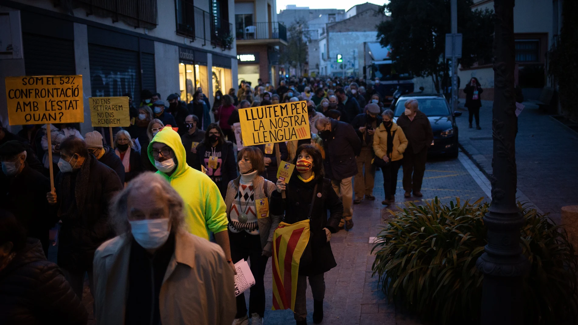 Varias personas con carteles durante una manifestación contra el establecimiento de un 25% de castellano en las escuelas catalanas, frente a la escuela Turó del Drac, en Canet de Mar