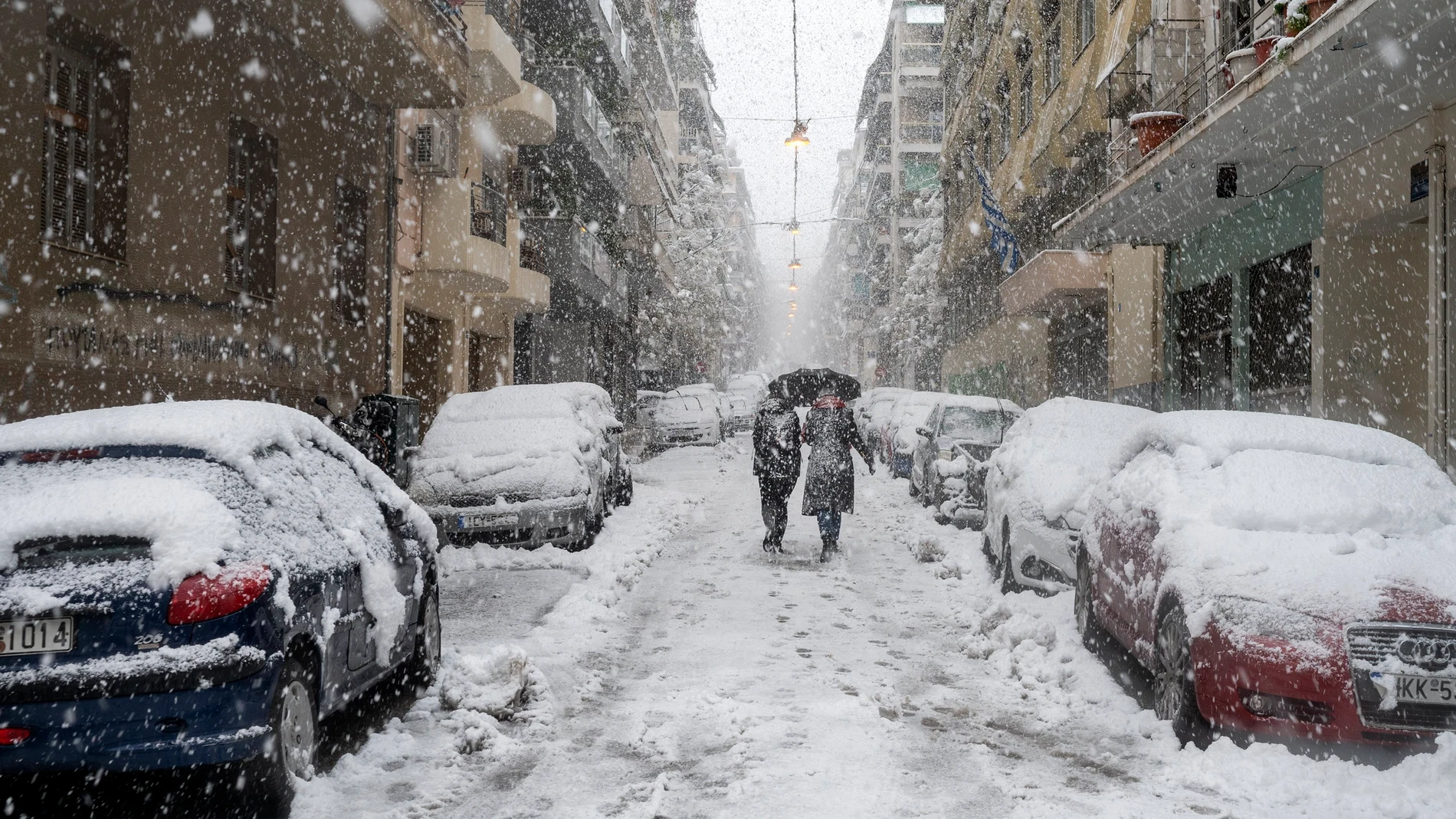 La gente camina por una calle durante una fuerte nevada en Atenas, Grecia