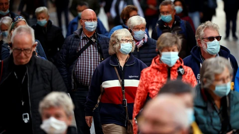 Vista general de una céntrica calle de la ciudad repleta de viandantes con mascarilla