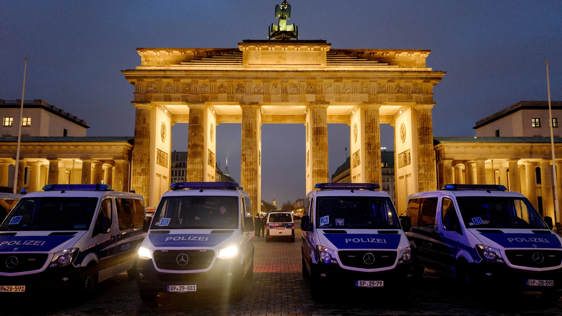 Coches de policía frente a la Puerta de Brandenburgo mientras el Parlamento debate nuevas instrucciones para la vacunación