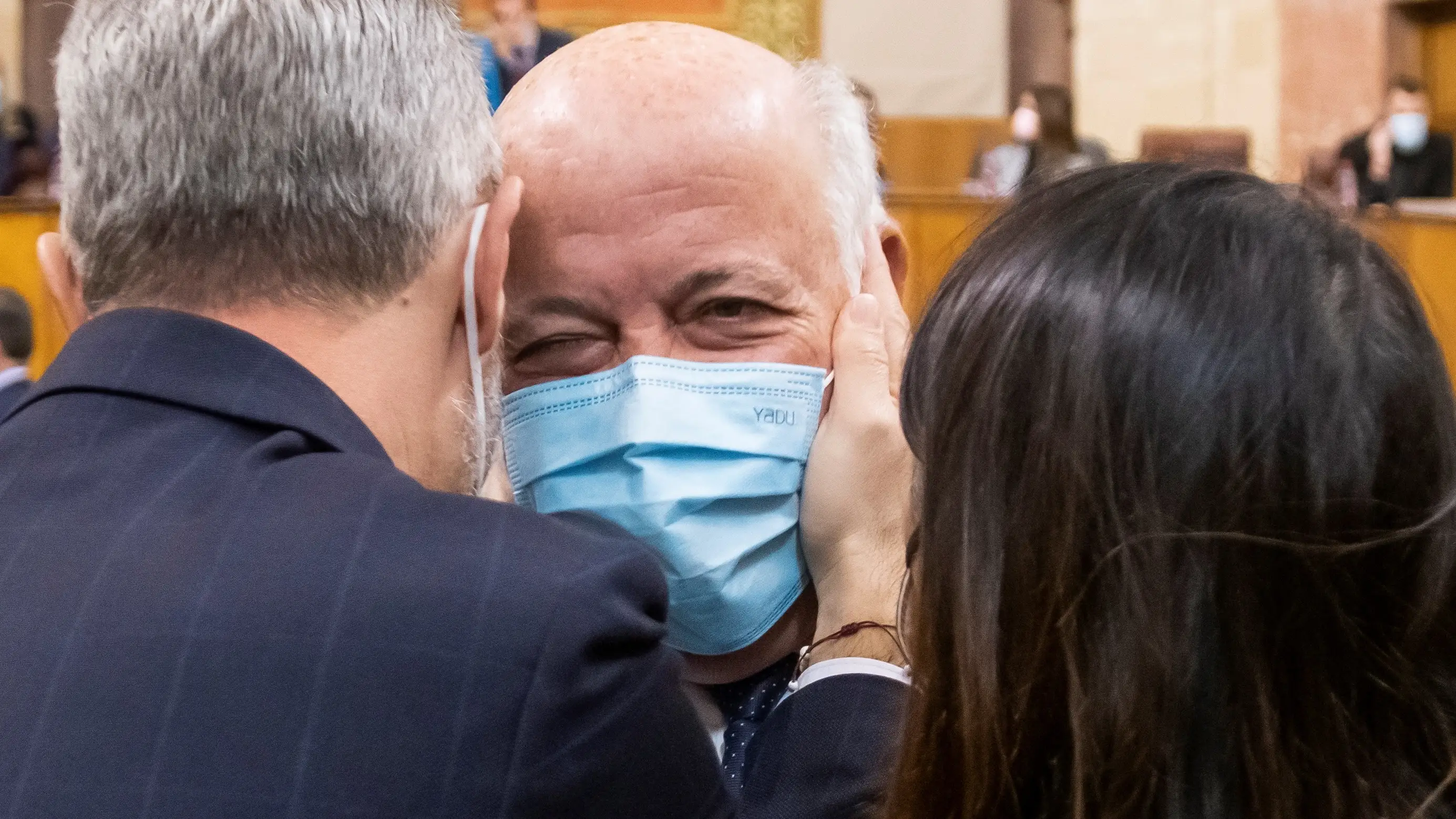 El consejero de Salud, Jesús Aguirre (c), es felicitado por el consejero de Hacienda, Juan Bravo (i) que le coge la cara junto a la presidenta del Parlamento de Andalucía, Marta Bosquet (d). EFE/ Raúl Caro.