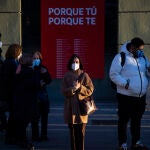 Mujer esperado en un paso de peatones frente a una sucursal del banco Santander