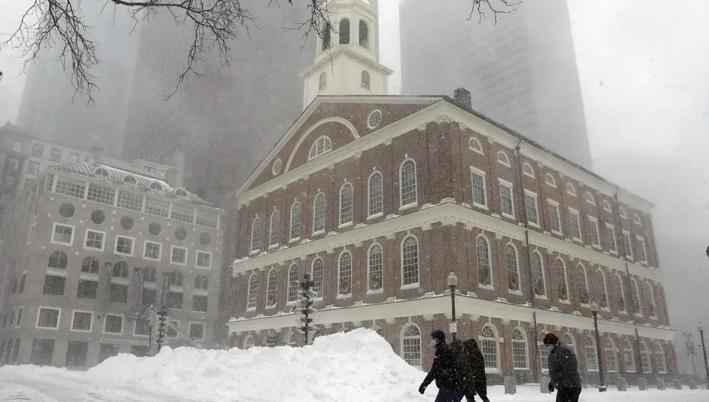 La gente camina en la nieve afuera de Faneuil Hall, el sábado 29 de enero de 2022, en Boston.