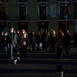 Gente con mascarilla y sin ella en un paso de peatones en Madrid.