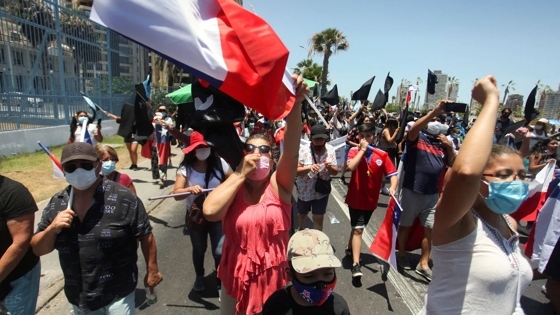 Los manifestantes participan en una manifestación contra la migración y la delincuencia, en Iquique, Chile