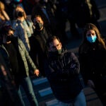 Gente con mascarilla y sin ella en un paso de peatones en Madrid.