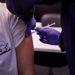 Detalle de una persona, de entre 18 y 29 años, recibiendo la tercera dosis de la vacuna contra el Covid-19, en el Centro de Salud Pavones de Madrid (España)