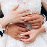 El novio y la novia se están poniendo anillos de boda, vista frontal de las manos