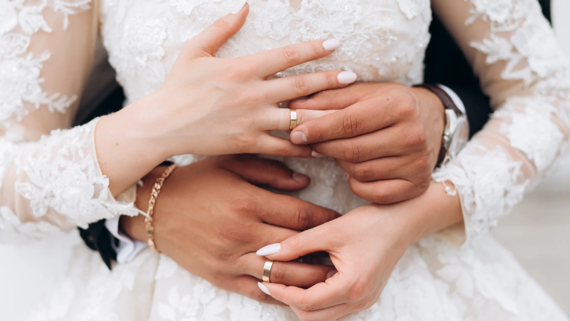 El novio y la novia se están poniendo anillos de boda, vista frontal de las manos