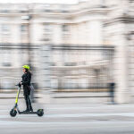 Una persona conduce un patinete eléctrico Link por Madrid