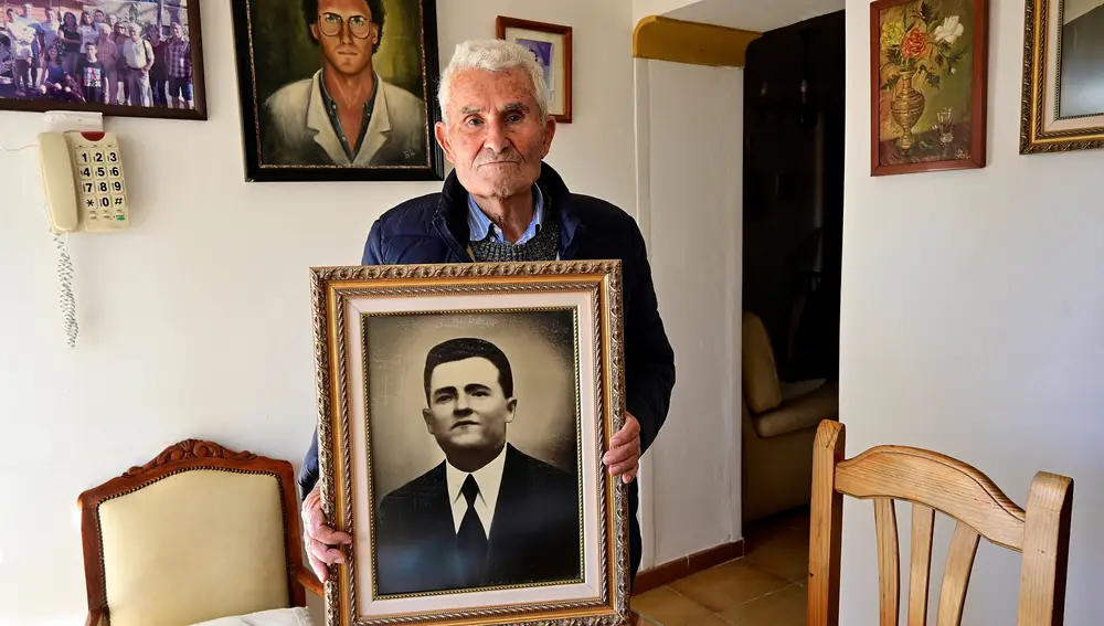 Pepe Alarcón García, de 90 años, fotografiado con el retrato de su padre en su casa en Vélez-Málaga. EFE/Jorge Zapata