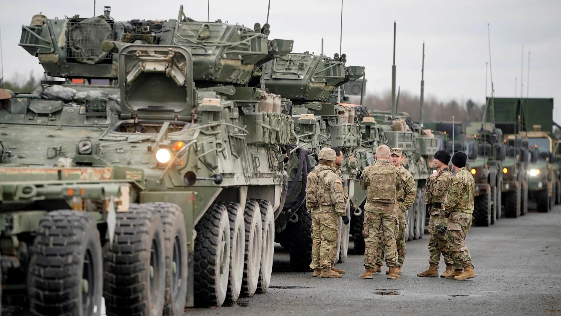 Soldados del 2º Regimiento de Caballería de Estados Unidos conversa junto a varios vehículos militares antes de partir a Rumanía, en la Base Aérea estadounidense de Vilseck (Alemania)