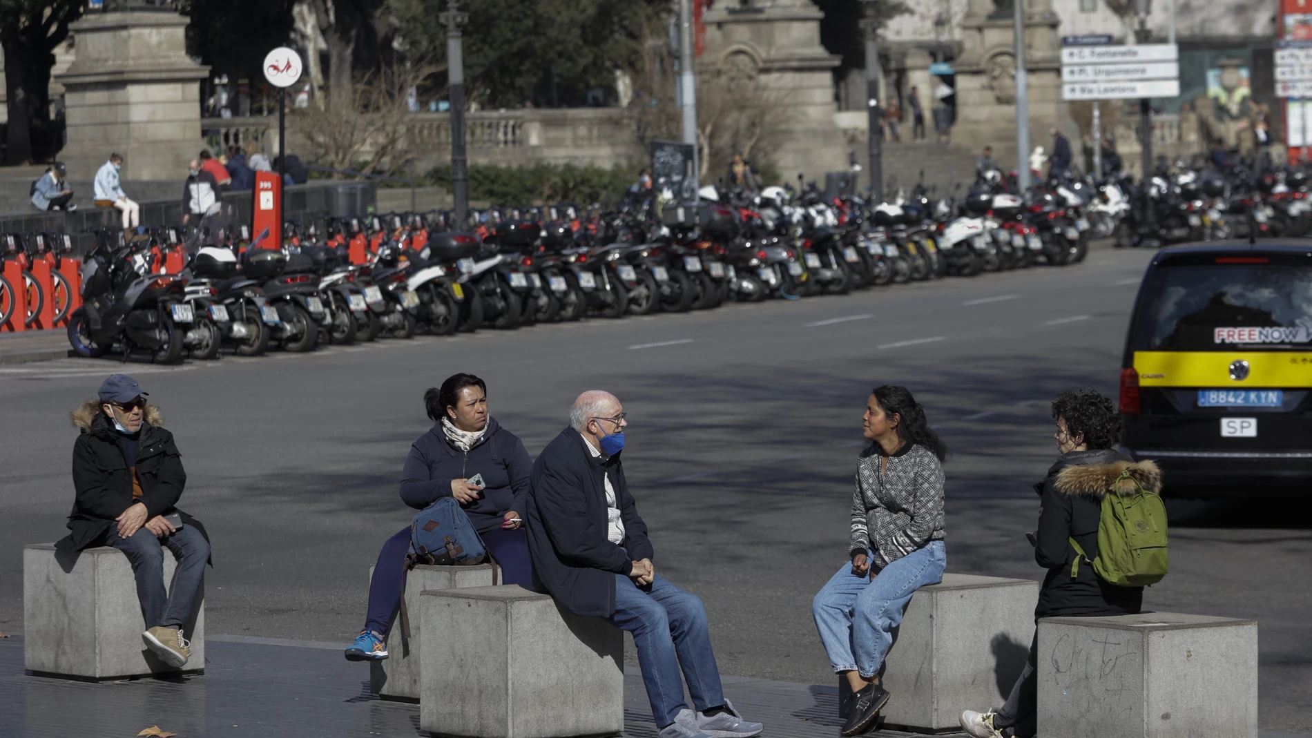 Unas personas descansan y hablan en el centro de Barcelona (Cataluña)