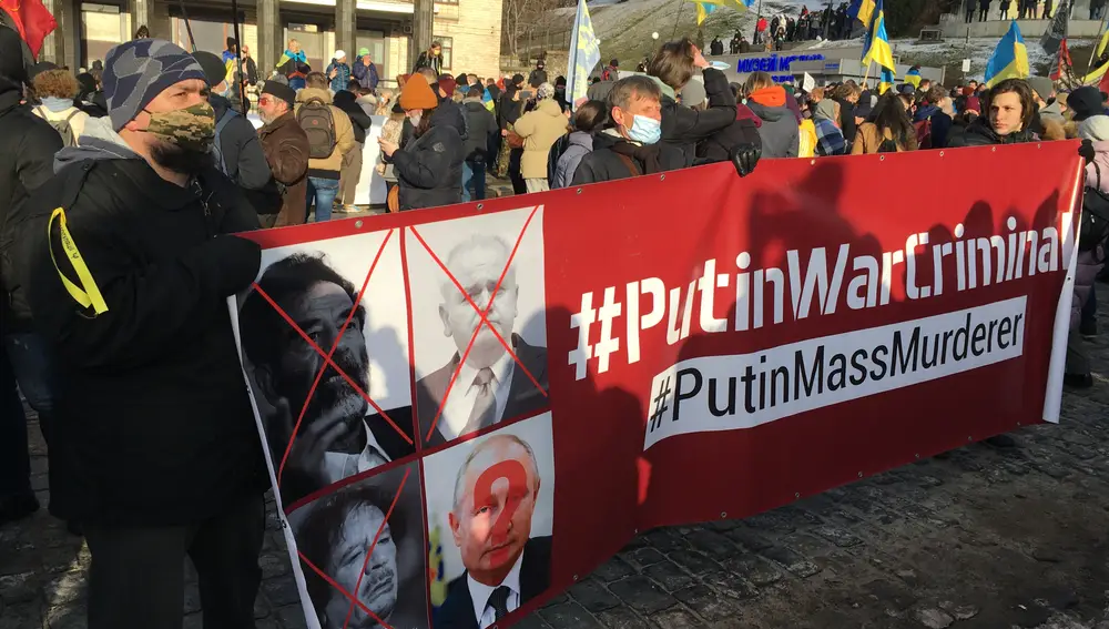 Ucranianos sosteniendo una pancarta en contra de Vladimir Putin.