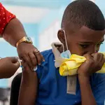 Un niño recibe una dosis de la vacuna Sinovac contra la Covid-19, en una escuela del barrio Capotillo, en Santo Domingo (República Dominicana)