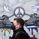 Un hombre pasa junto a una obra de arte callejero de Laika en Roma