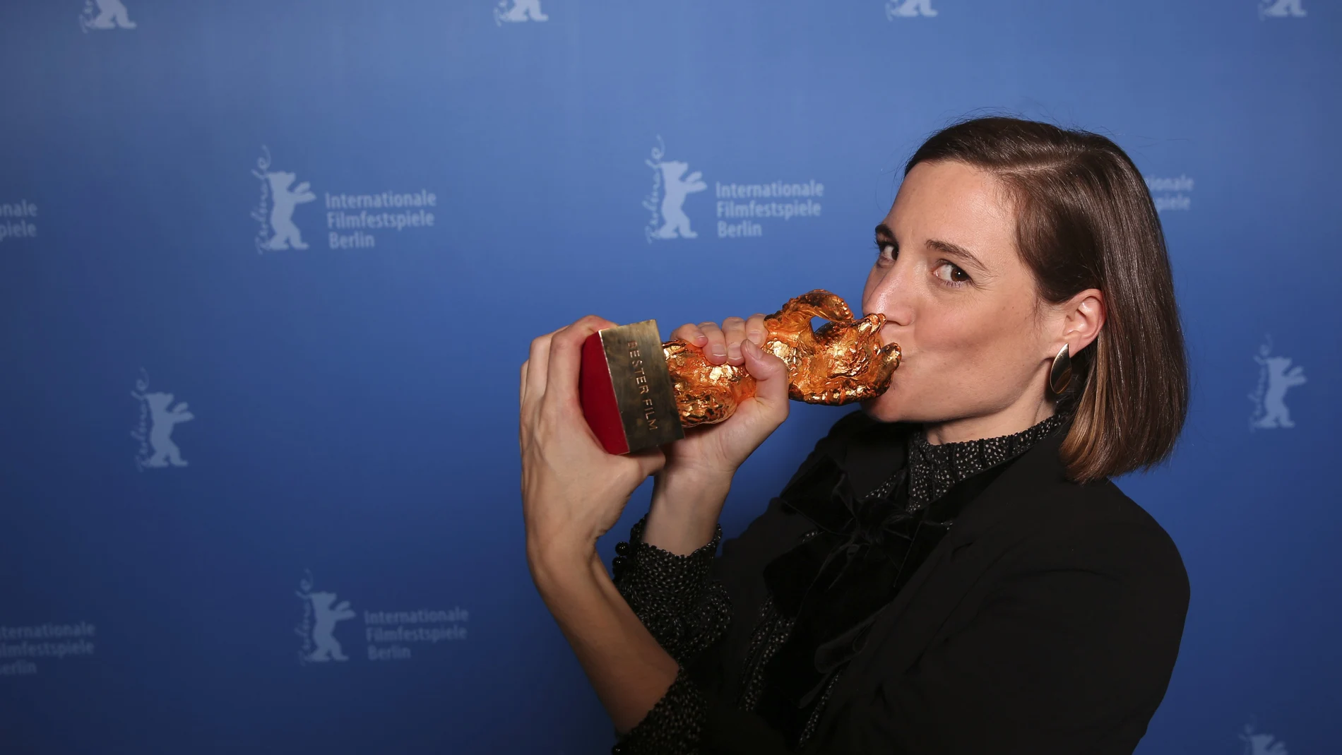 Carla Simon besa el Oso de Oro tras obtener el premio por su película "Alcarràs" en el Festival de Berlín
