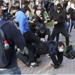 Manifestantes agredes a policías en el barrio de Vallecas de Madrid, durante un acto de Vox. Entre los identificados había personas del entorno de Podemos
