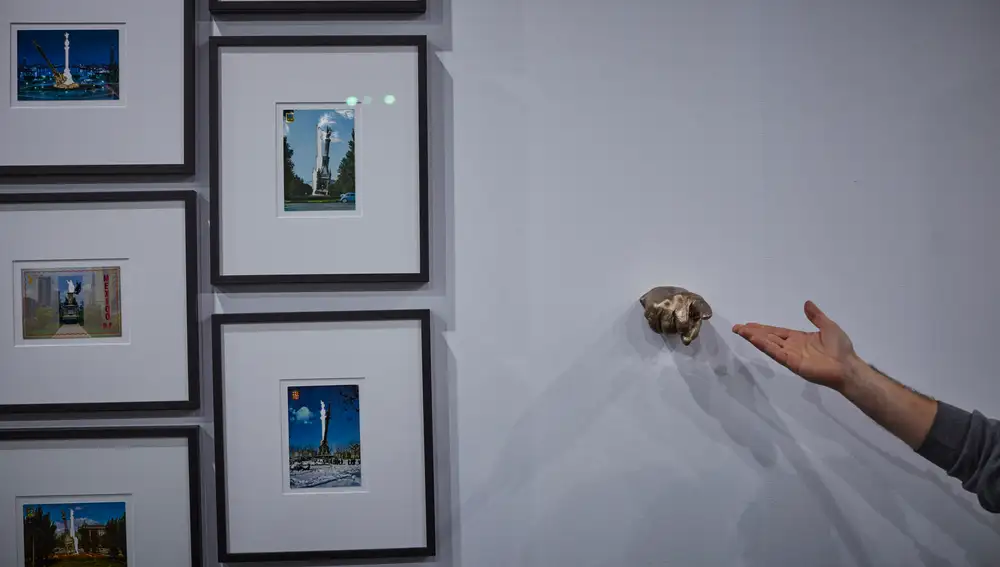 El dedo acusador de Eugenio Merino junto a sus postales con esculturas de Colón