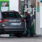 Una mujer reposta combustible en una gasolinera