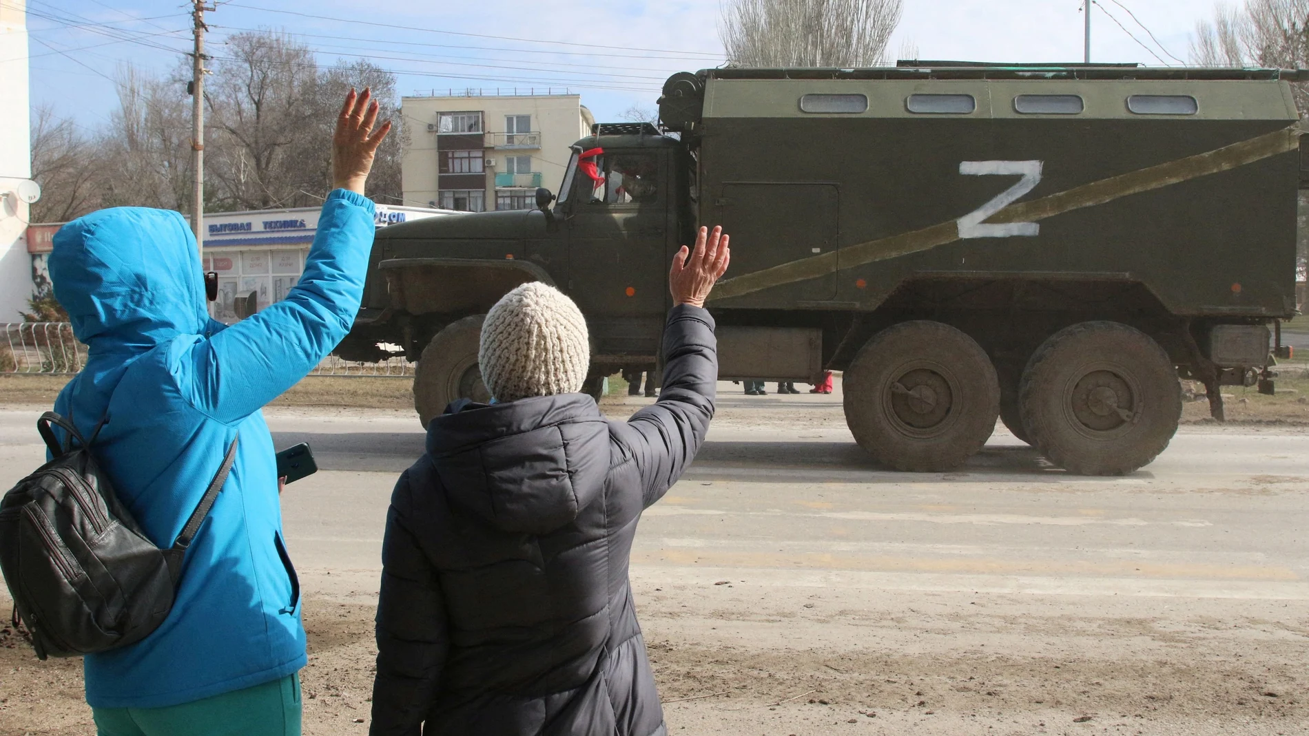 La gente saluda mientras un camión militar del ejército ruso conduce por una calle de Crimea | Fuente: REUTERS