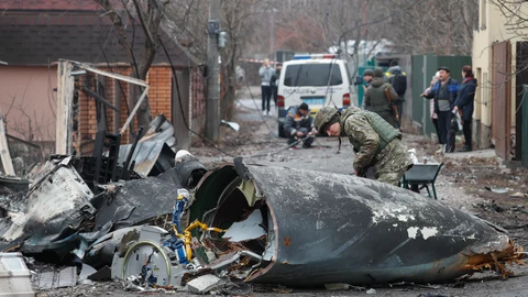 Kiev (Ucrania), 25/02/2022.- Un soldado observa los restos de un avión militar derribado durante la noche del 25 de febrero de 2022 en Kiev, Ucrania. Las tropas rusas entraron en Ucrania el 24 de febrero, lo que llevó al presidente del país a declarar la ley marcial. EFE/SERGEY DOLZHENKO
