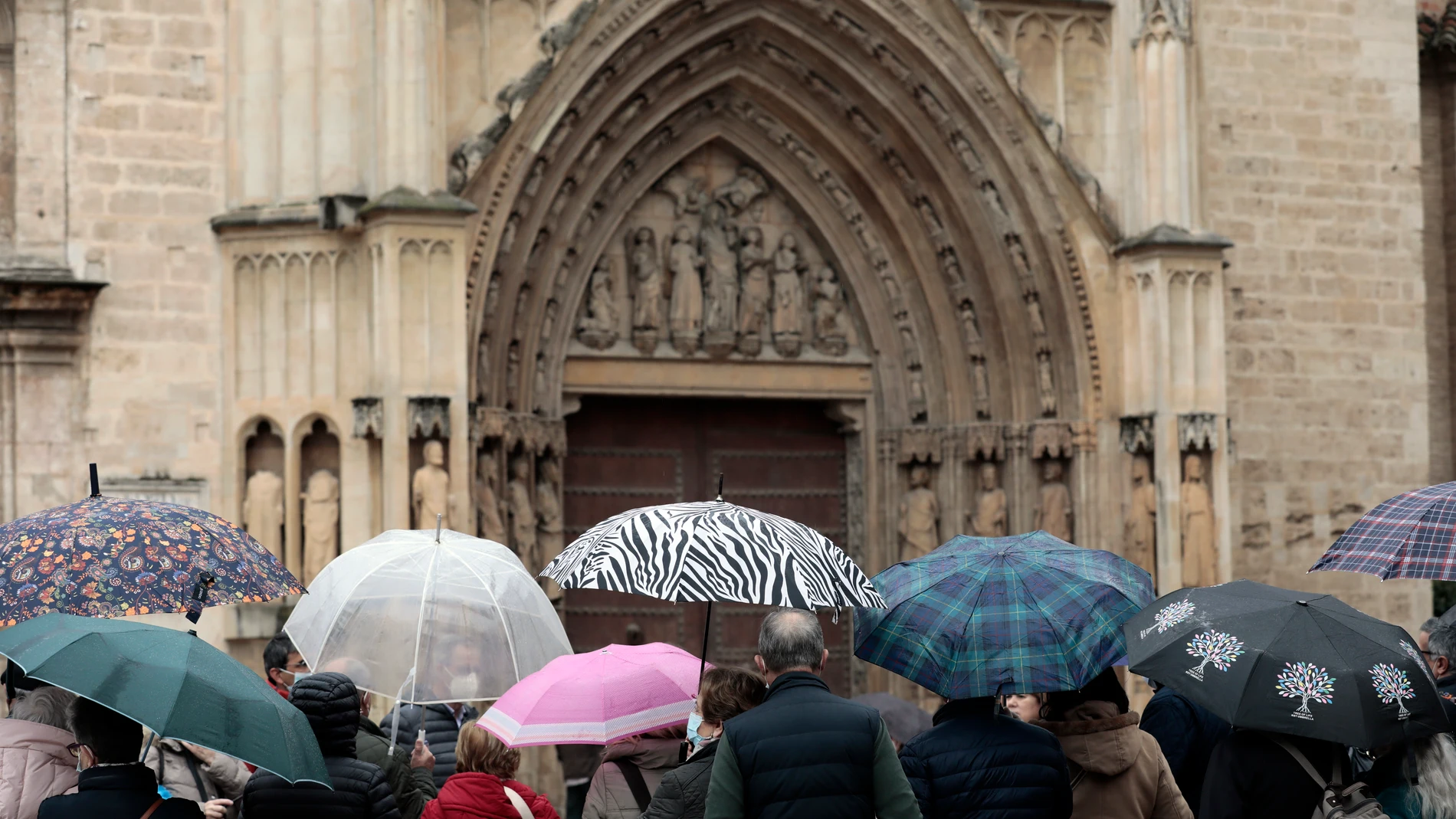 Varias personas se protegen del agua con paraguas en Valencia