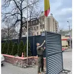 Un policía, en el momento de arriar la Bandera Nacional de la embajada
