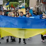 Varios jóvenes con una bandera de Ucrania, participan en una segunda concentración para apoyar a Ucrania tras los ataques recibidos por parte de Rusia, en la plaza de la Cruz Roja de Murcia