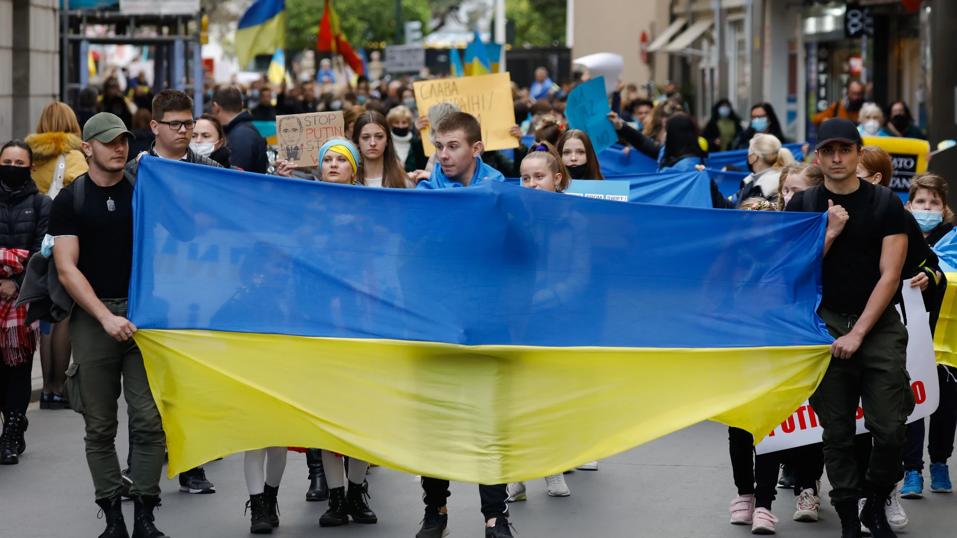 Varios jóvenes con una bandera de Ucrania, participan en una segunda concentración para apoyar a Ucrania tras los ataques recibidos por parte de Rusia, en la plaza de la Cruz Roja de Murcia