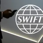 Un hombre pasa junto al logo de la cooperativa SWIFT en Toronto