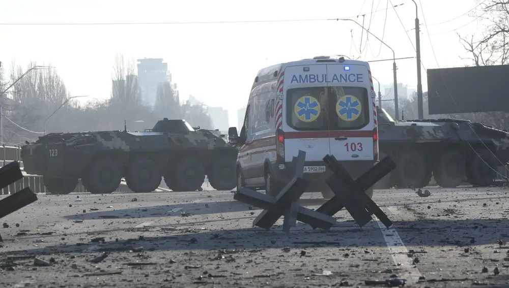 An ambulance parked near a barricade and Ukrainian armored vehicles in a street in Kyiv, Ukraine, Saturday, Feb. 26, 2022. Russian troops stormed toward Ukraine's capital Saturday, and street fighting broke out as city officials urged residents to take shelter. (AP Photo/Efrem Lukatsky)