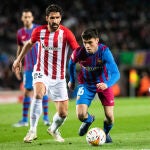 Pedri se lleva el balón ante Raúl García en el Barcelona - Athetic Club